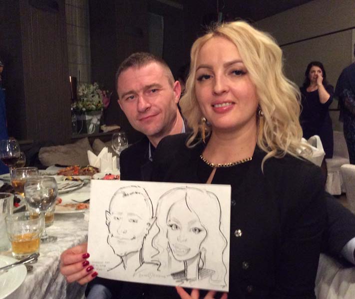 Денис и Евгения демонстрируют свадебный шарж нарисованный шаржистом Мишелем