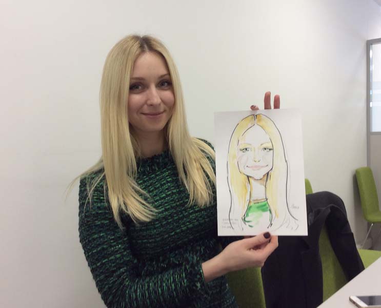 Лина держит свой шарж на свадьбе от шаржиста Мишеля