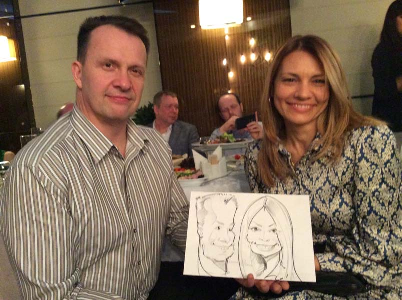 Евгений и Ольга позируют шаржисту на свадьбе в 