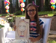 Даниэлла в очках и с бантиком радуется своему шаржу