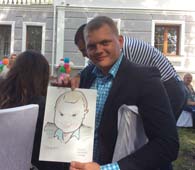 Григорий держит свой рисунок и пытается хмуриться