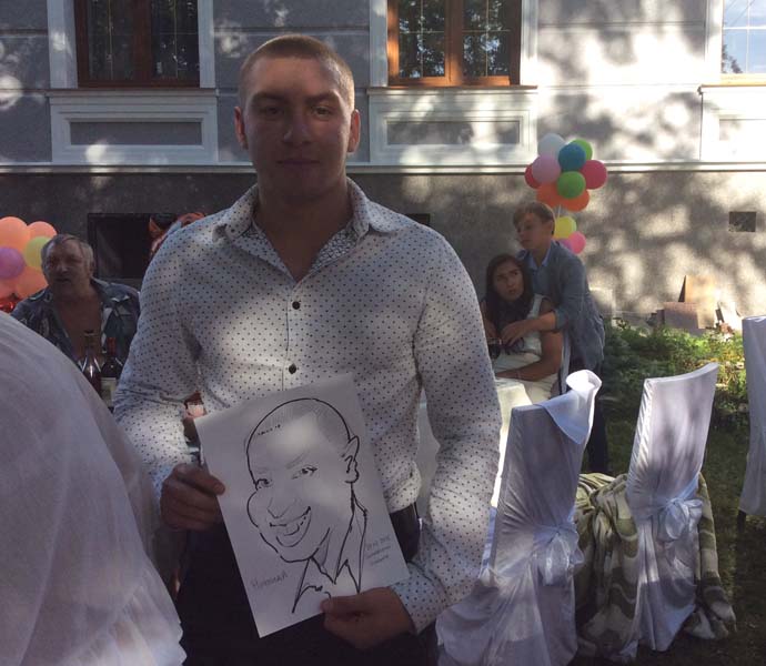 Молодой человек показывает свою карикатуру гостям