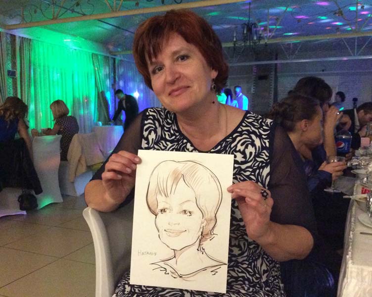 Наталья держит шарж от шаржиста Мишеля на свадьбе в 