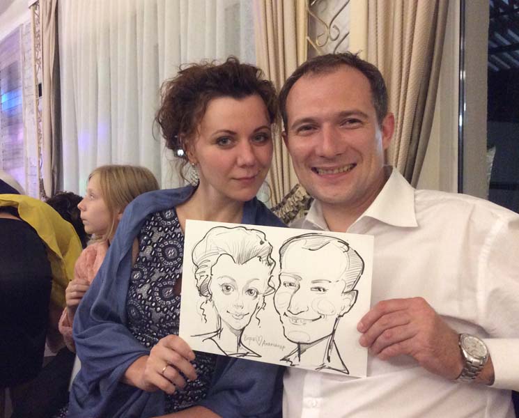 Вера и Александр показывают шарж от шаржиста Михаила Шабалина на свадьбе