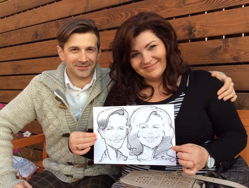 Василий и Юлия держат шарж от Михаила Шабалина на свадьбе